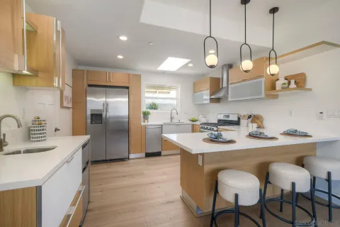 a kitchen with stainless steel appliances granite countertop a sink a stove and a wooden floors
