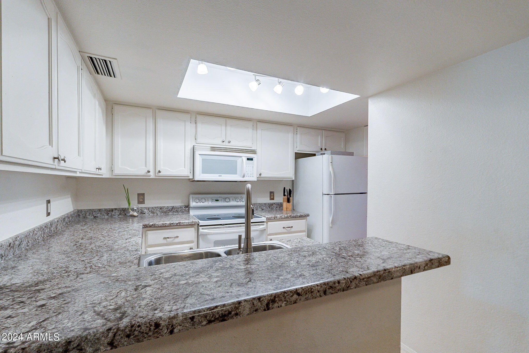 170 East Guadalupe Road, Unit 67 Gilbert, AZ 85234 - Photo 9 of 29 a kitchen with stainless steel appliances granite countertop a sink refrigerator and cabinets