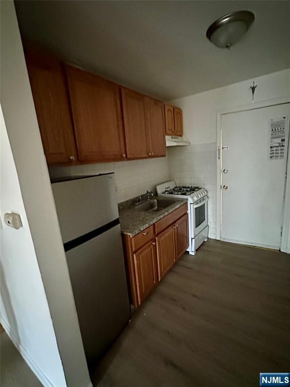 87 West Main Street, Unit D Bergenfield, NJ 07621 - Photo 3 of 7 a kitchen with a sink a stove top oven a refrigerator and cabinets