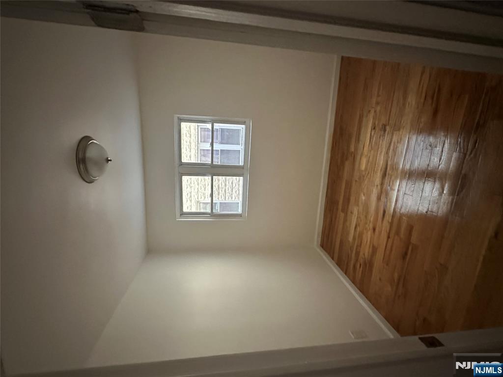 87 West Main Street, Unit D Bergenfield, NJ 07621 - Photo 4 of 7 an empty room with wooden floor and windows