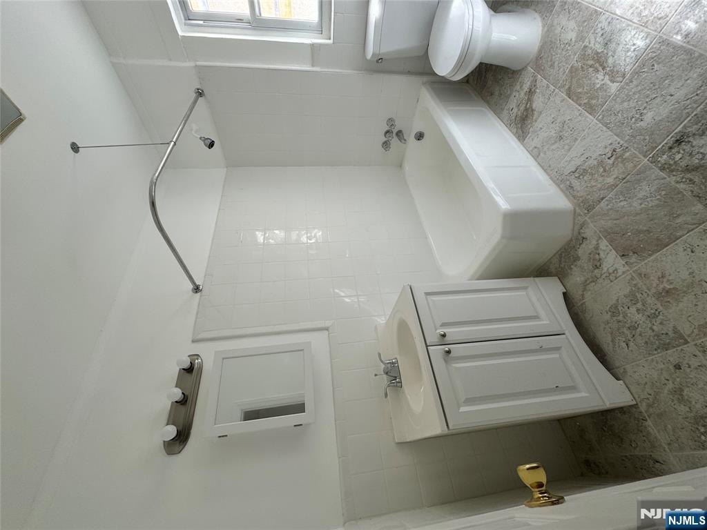 87 West Main Street, Unit D Bergenfield, NJ 07621 - Photo 5 of 7 a bathroom with a sink a toilet and bathtub