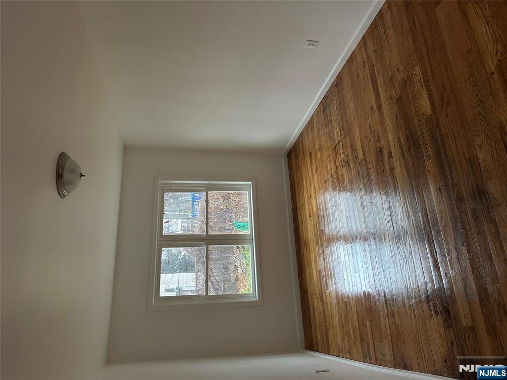 87 West Main Street, Unit D Bergenfield, NJ 07621 - Photo 6 of 7 a view of an empty room with wooden floor and a window