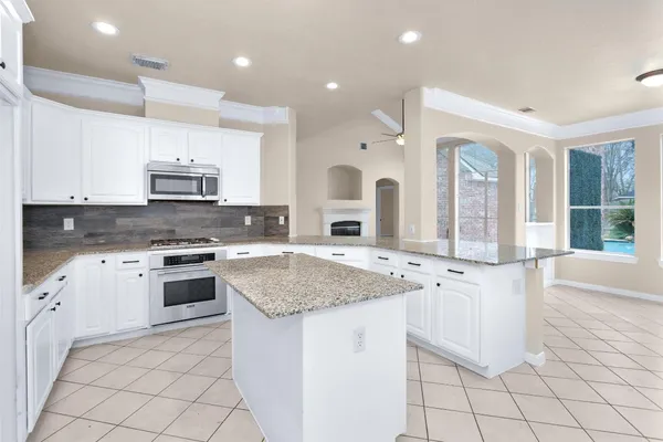 a large kitchen with kitchen island a sink stainless steel appliances and cabinets