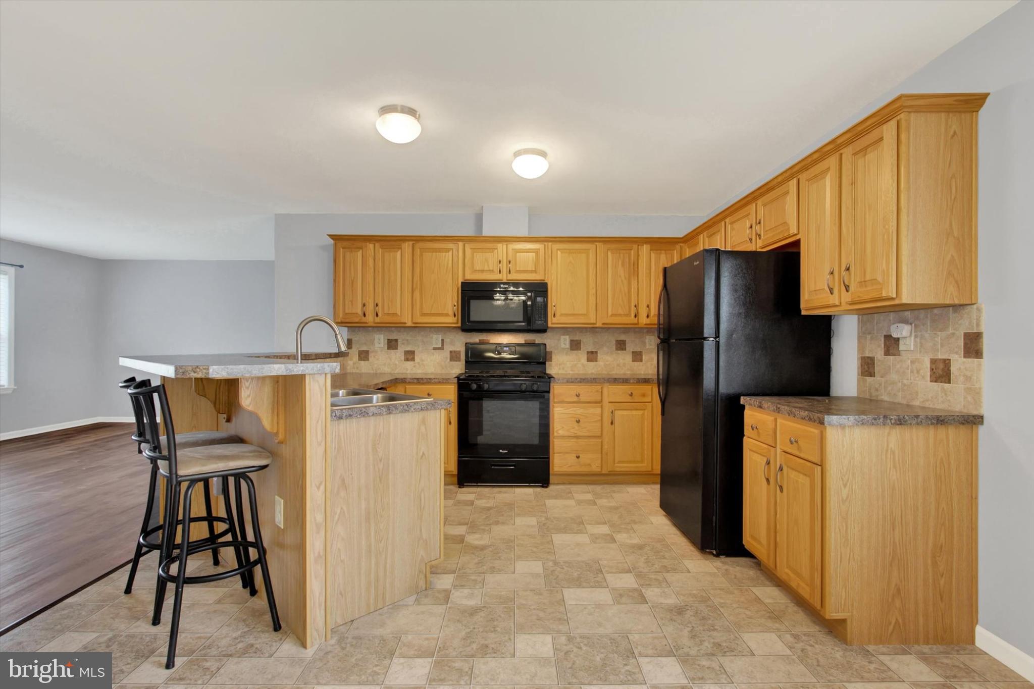 893 Georgetown Road Littlestown, PA 17340 - Photo 8 of 35 a kitchen with a refrigerator a stove top oven a sink and dishwasher