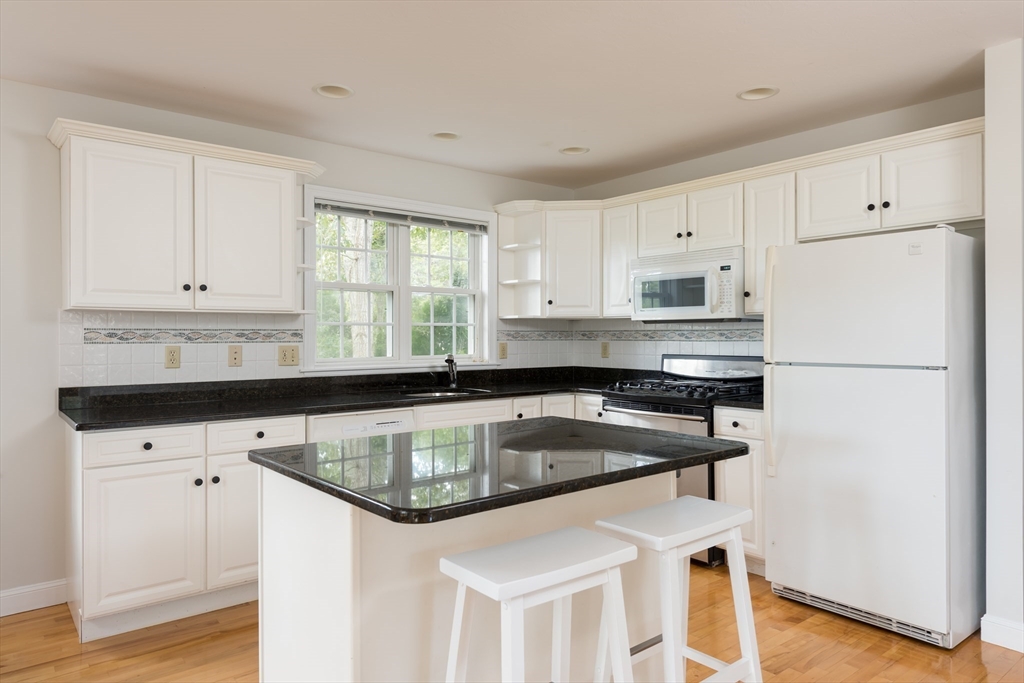 376 Monomoscoy Road Mashpee, MA 02649 - Photo 14 of 31 a kitchen with stainless steel appliances granite countertop a sink a stove a refrigerator a center island and cabinets