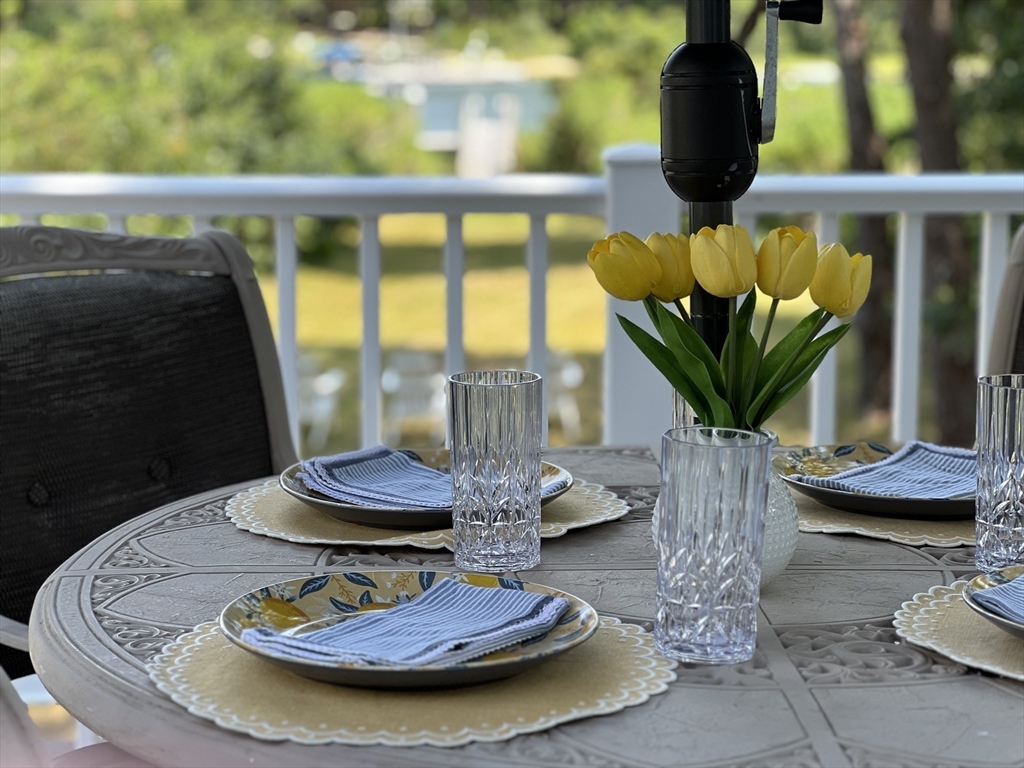 376 Monomoscoy Road Mashpee, MA 02649 - Photo 19 of 31 a view of a dining room with furniture a potted plant and wooden floor