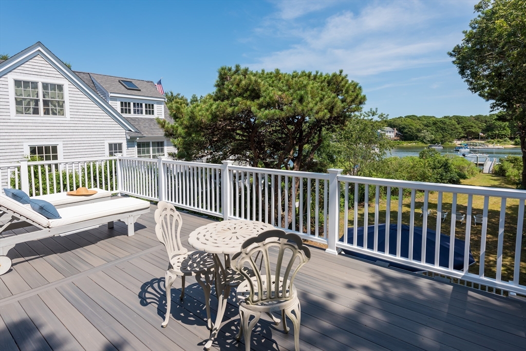 376 Monomoscoy Road Mashpee, MA 02649 - Photo 22 of 31 a view of a chair and table on the deck