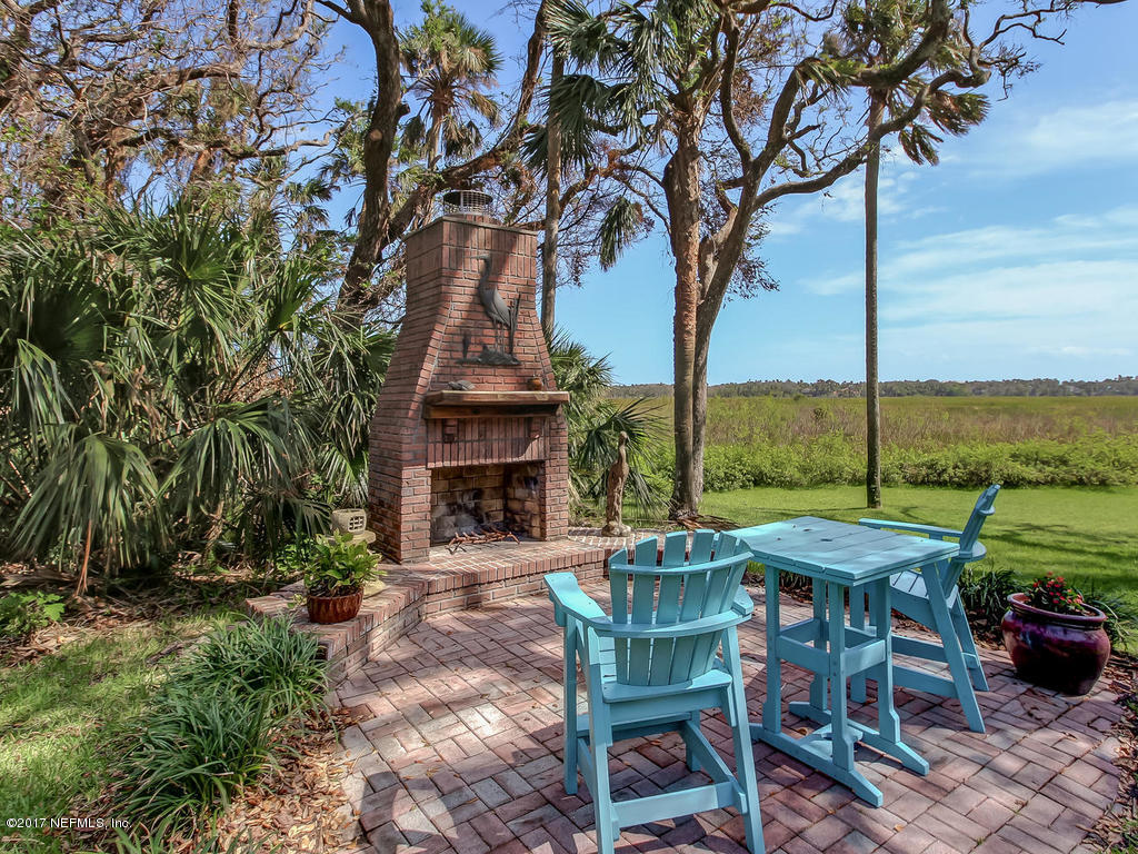 1198 Neck Road Ponte Vedra Beach, FL 32082 - Photo 74 of 101 a view of a patio with table and chairs under an umbrella with wooden fence
