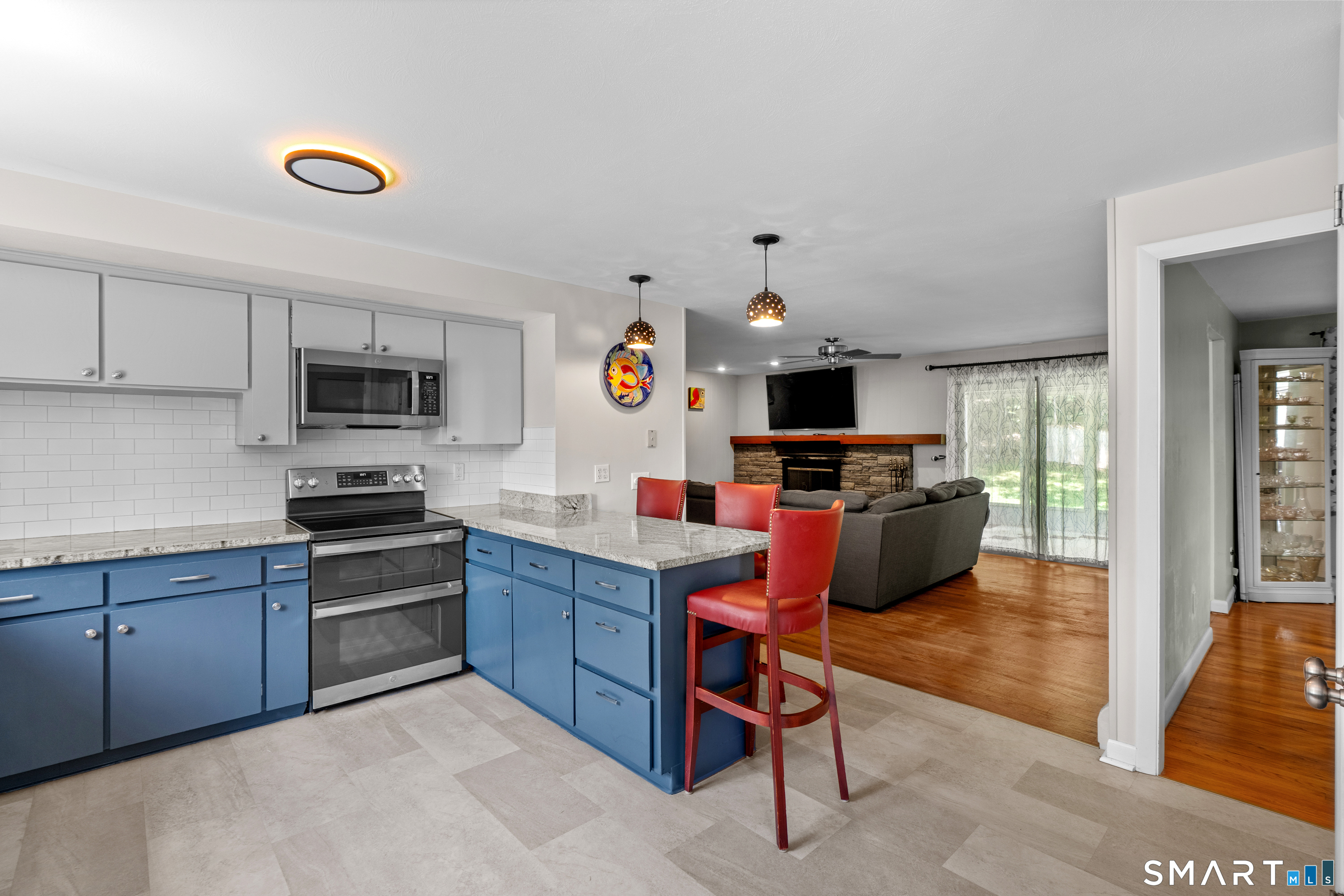 107 Round Hill Road Wethersfield, CT 06109 - Photo 14 of 40 a kitchen with a refrigerator a stove top oven a sink dishwasher and a dining table with wooden floor