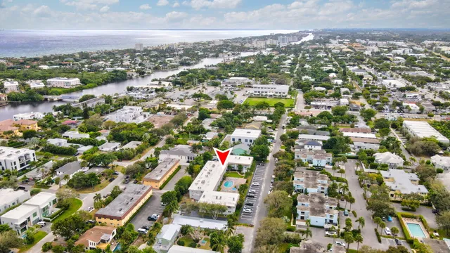 an aerial view of a houses with city street and lake view