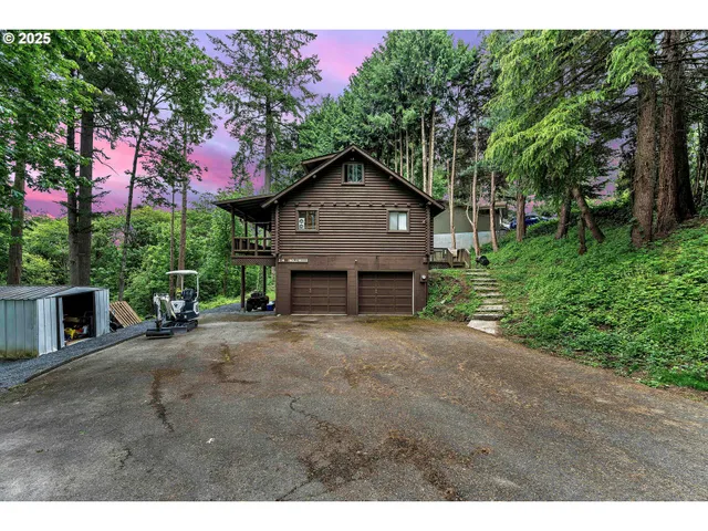 a front view of a house with a garden and tree