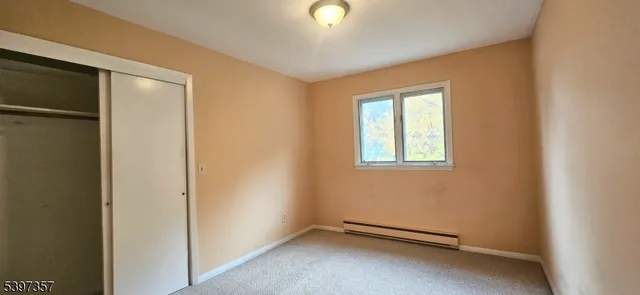 an empty room with windows and closet