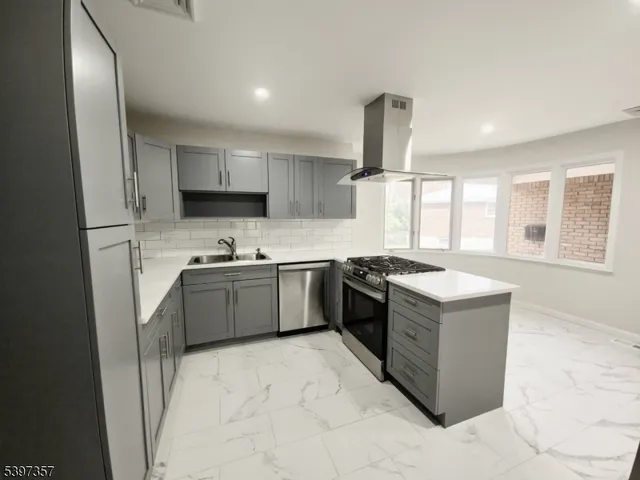 a kitchen with stainless steel appliances granite countertop a stove a sink and a refrigerator