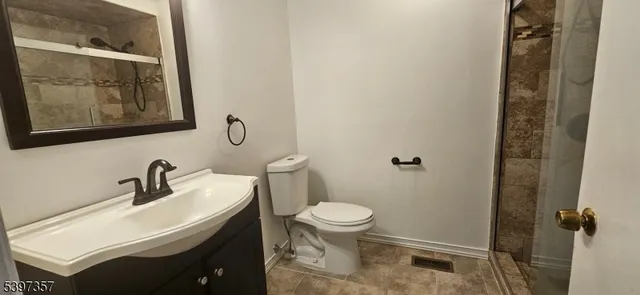 a bathroom with a sink and mirror with toilet