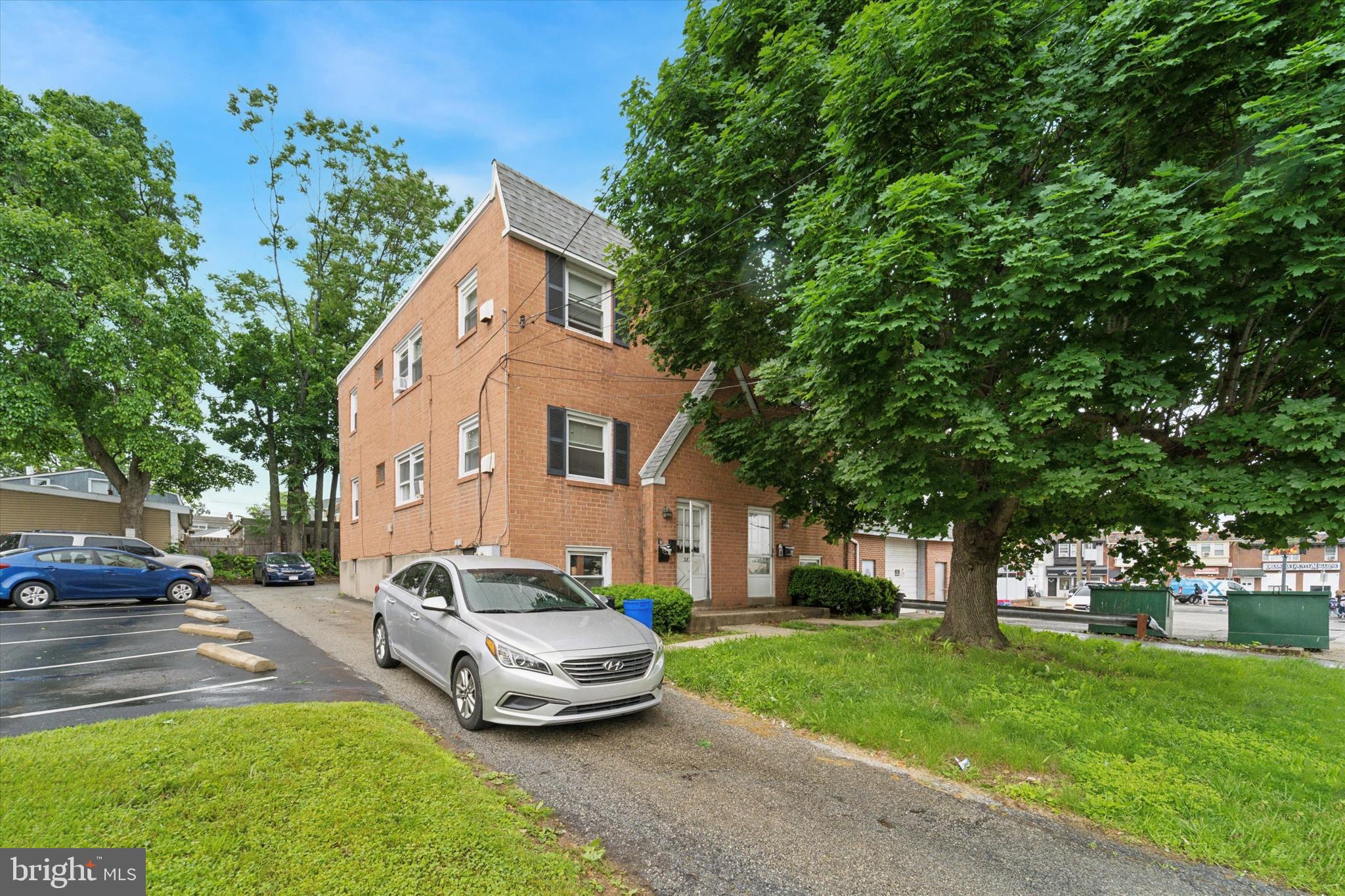a front view of a house with a garden and trees