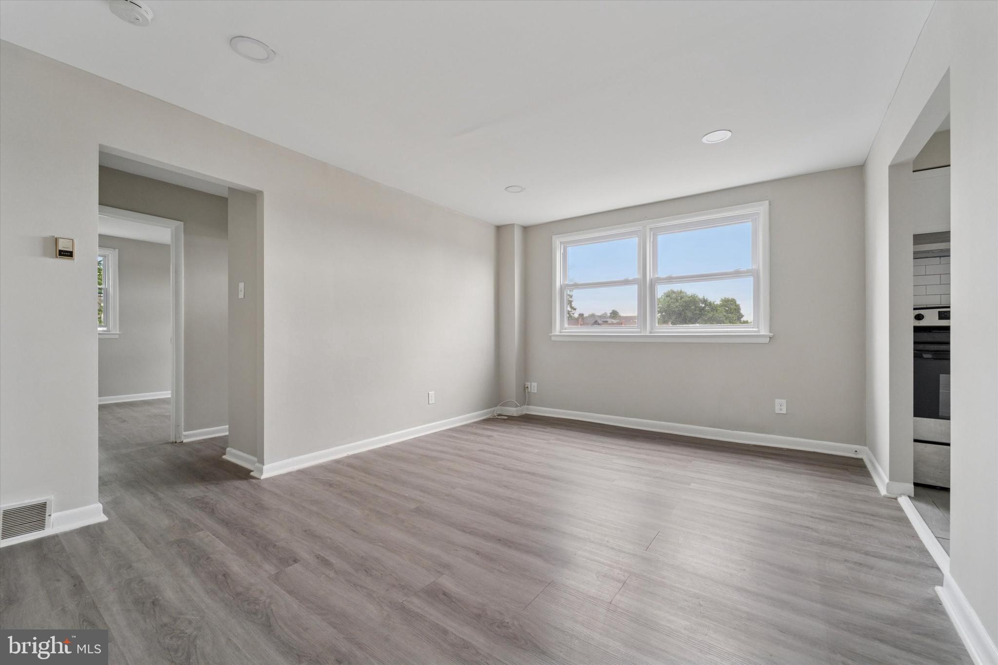 3819-3821 Garrett Road Drexel Hill, PA 19026 - Photo 13 of 24 a view of an empty room with wooden floor and a window