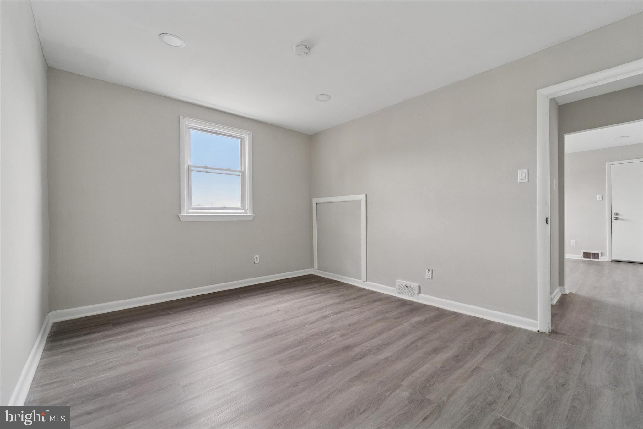 3819-3821 Garrett Road Drexel Hill, PA 19026 - Photo 17 of 24 an empty room with wooden floor and windows