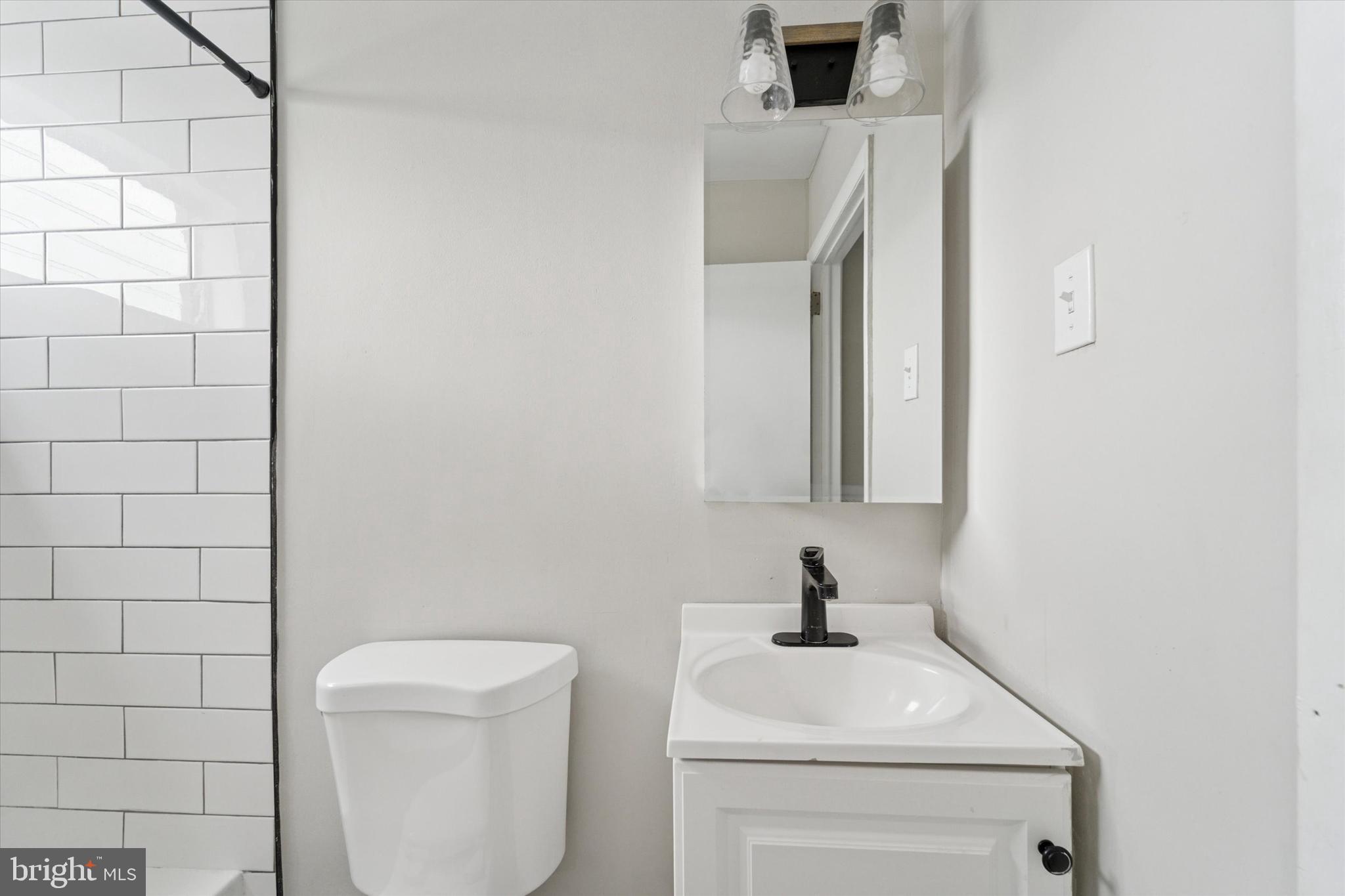 3819-3821 Garrett Road Drexel Hill, PA 19026 - Photo 22 of 24 a bathroom with a toilet a sink and mirror