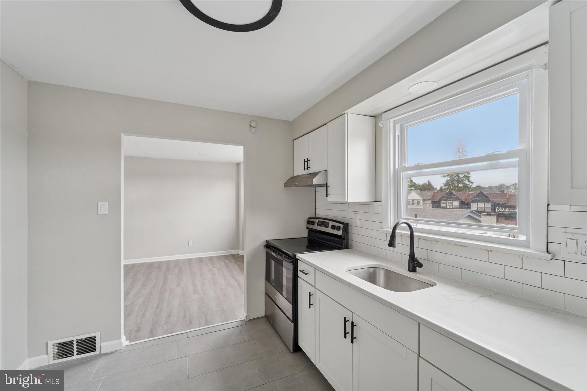 3819-3821 Garrett Road Drexel Hill, PA 19026 - Photo 9 of 24 a kitchen with a sink a stove and cabinets