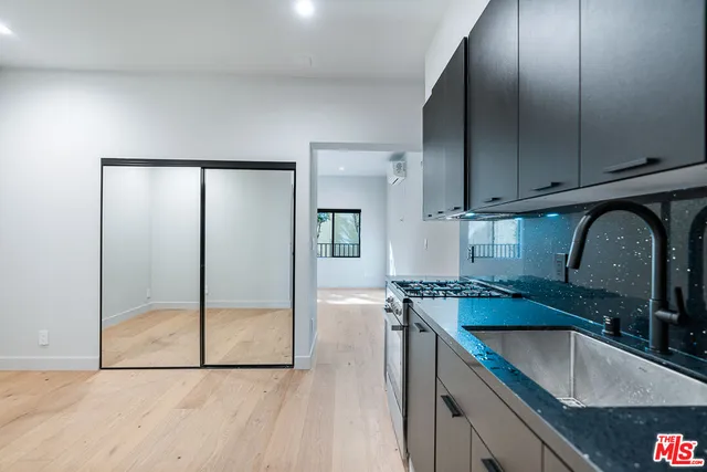 a kitchen with granite countertop a sink a counter top space cabinets and stainless steel appliances