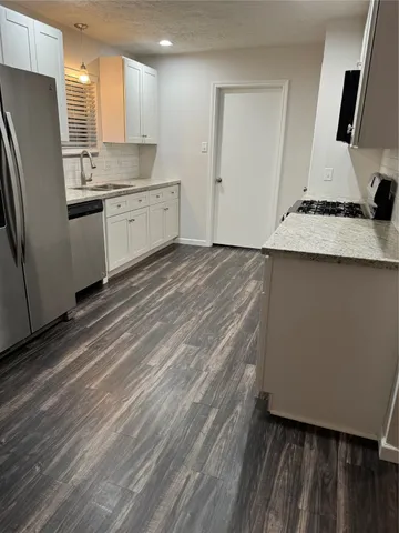 a kitchen with stainless steel appliances a refrigerator sink and stove