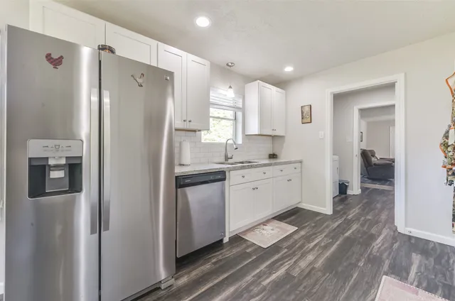 a kitchen with stainless steel appliances a refrigerator sink and microwave