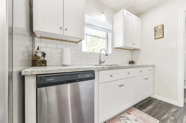a kitchen with granite countertop white cabinets and white appliances