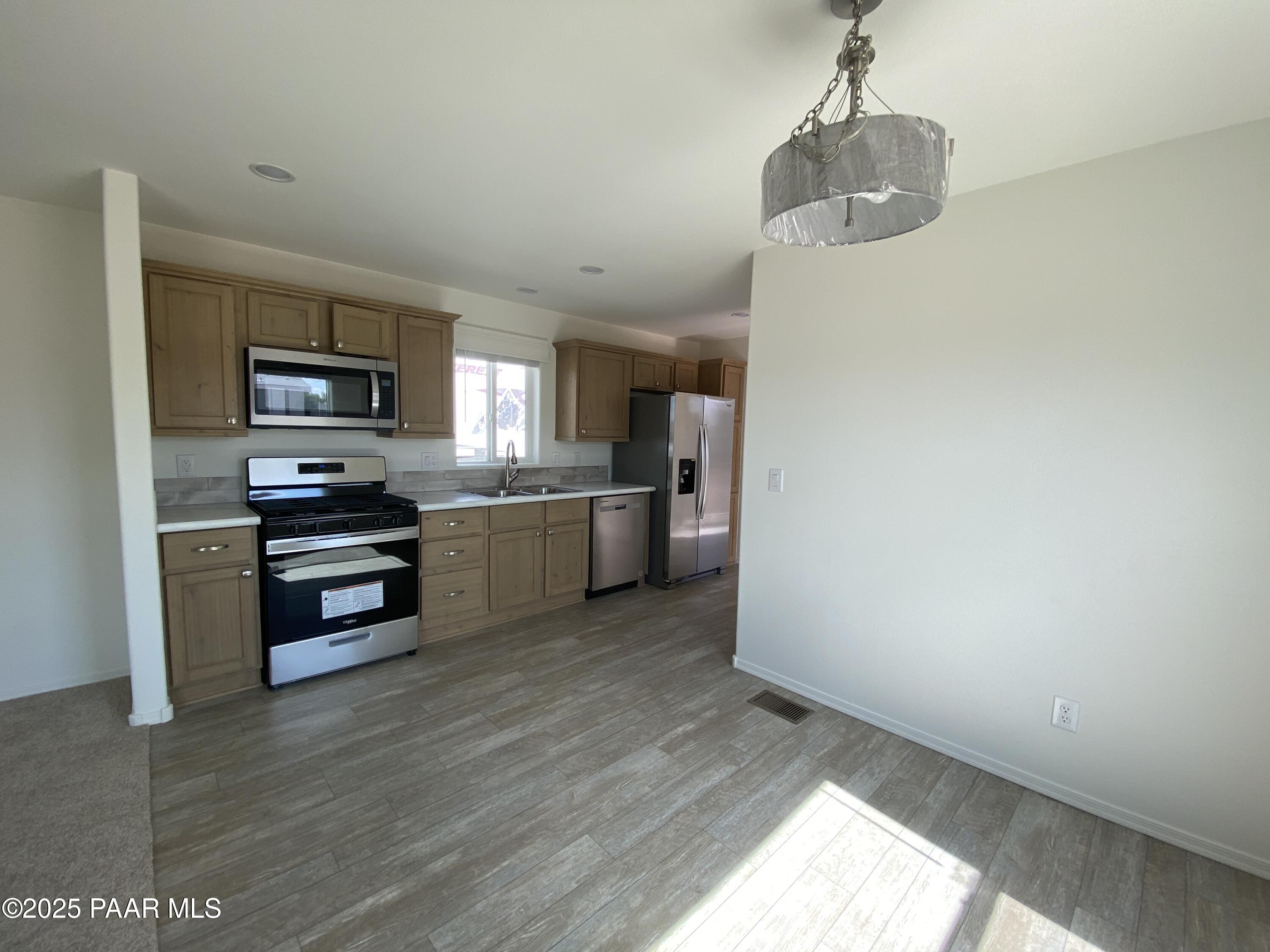 215 West Venice Way Paulden, AZ 86334 - Photo 29 of 40 a kitchen with granite countertop a refrigerator and a stove top oven