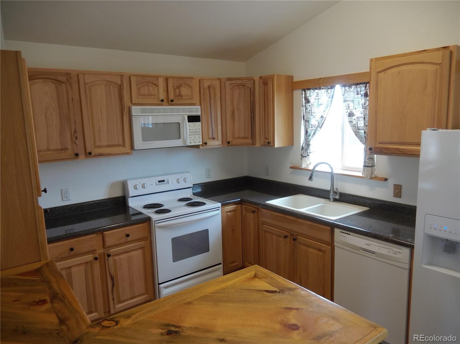 10299 Kingsview Road Austin, CO 81410 - Photo 11 of 40 a kitchen with a sink stove and cabinets