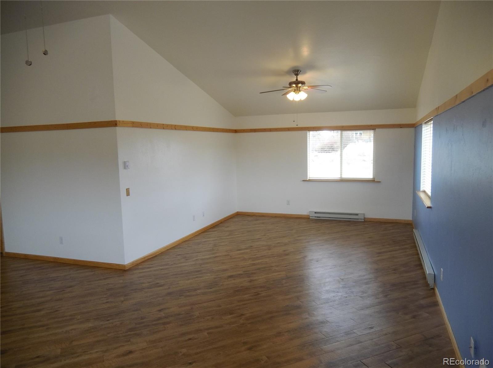 10299 Kingsview Road Austin, CO 81410 - Photo 13 of 40 an empty room with wooden floor and windows