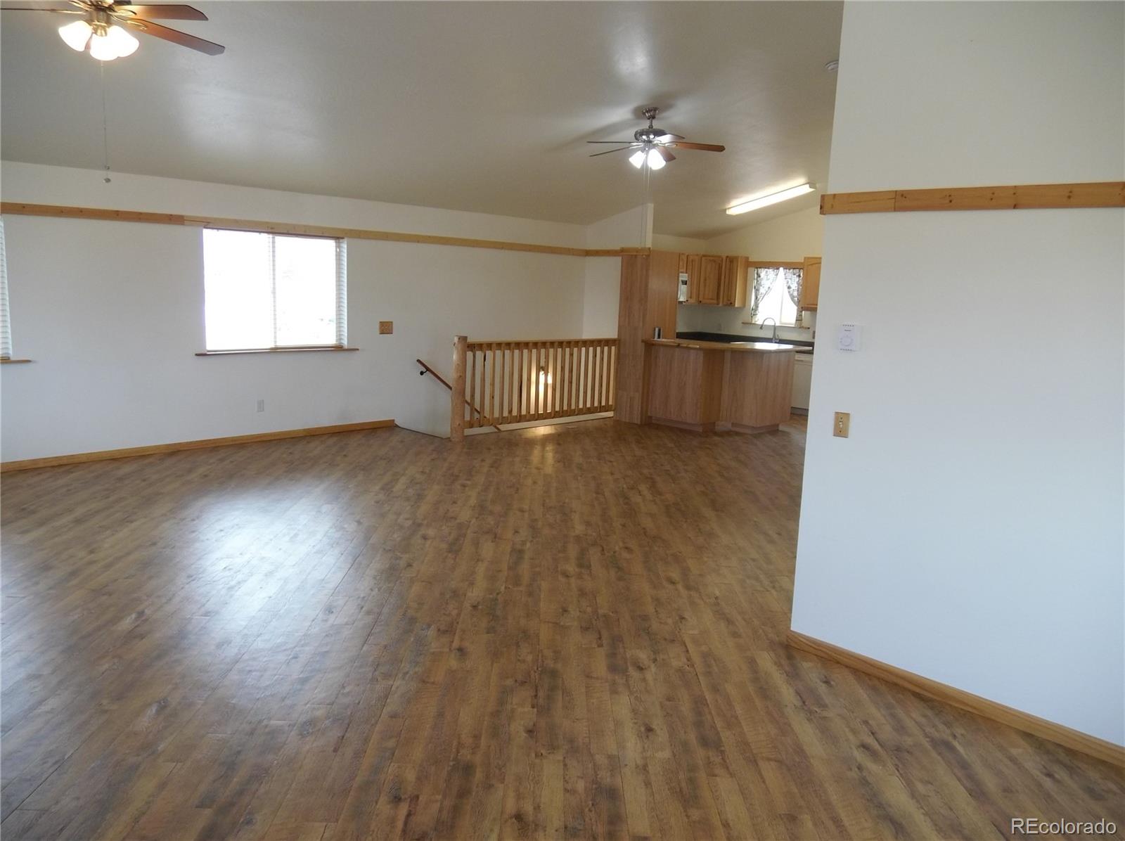 10299 Kingsview Road Austin, CO 81410 - Photo 16 of 40 an empty room with wooden floor kitchen view and windows