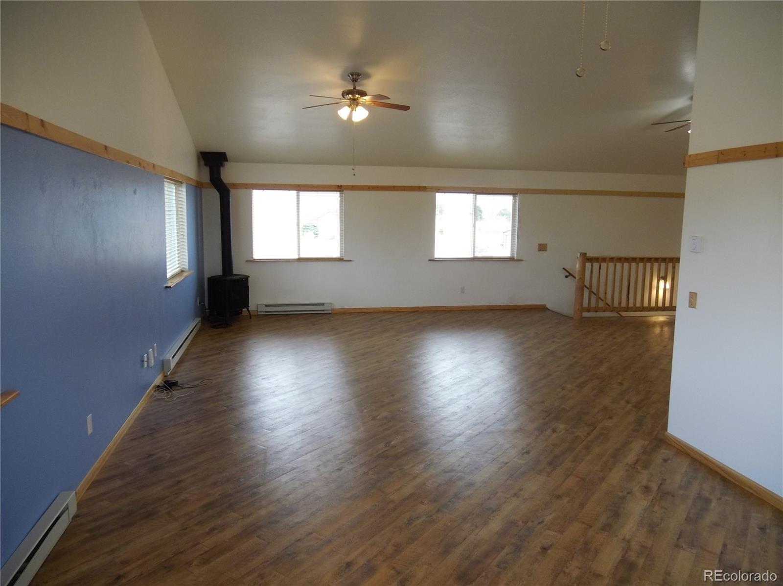 10299 Kingsview Road Austin, CO 81410 - Photo 17 of 40 an empty room with wooden floor and windows