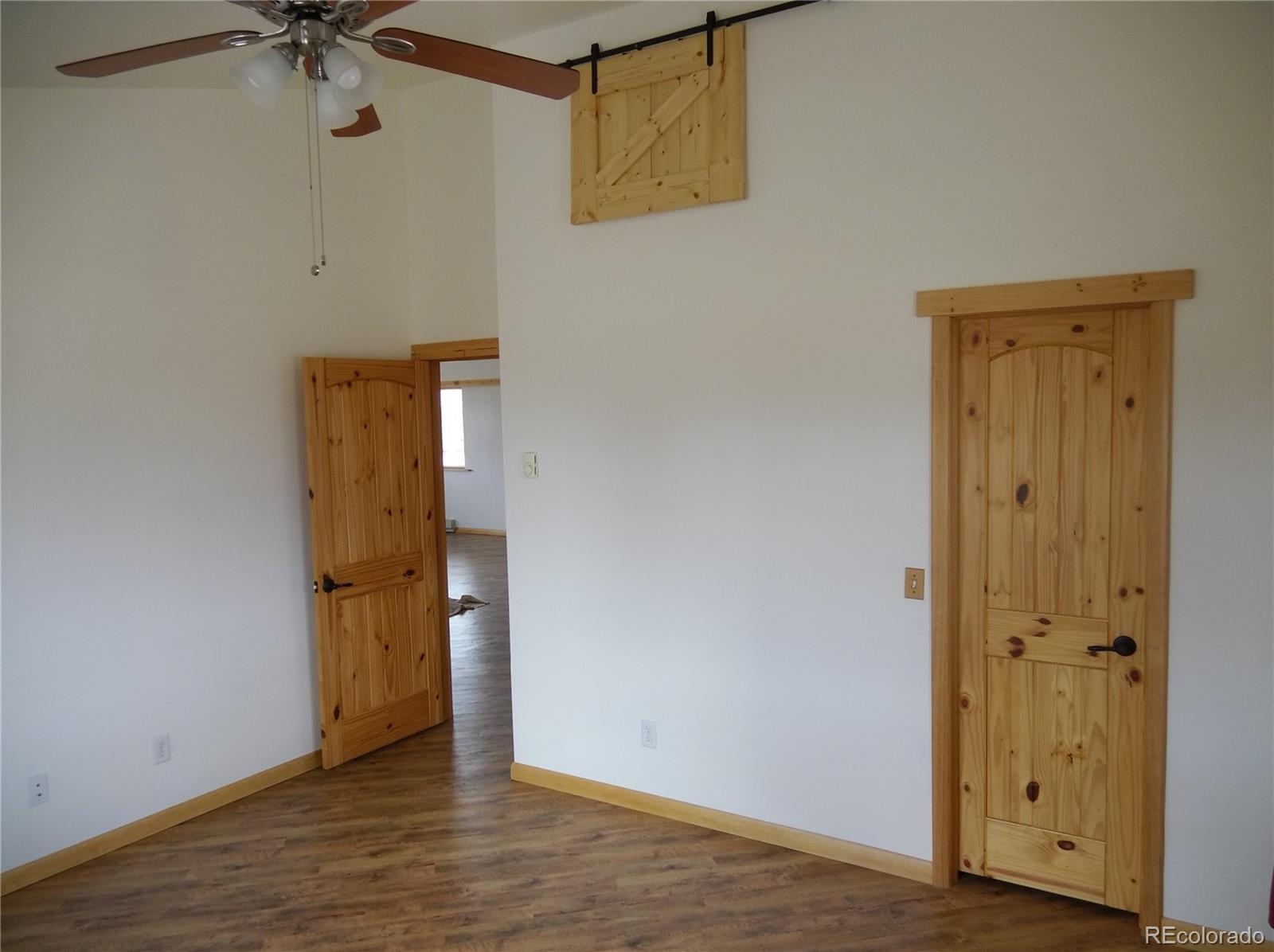 10299 Kingsview Road Austin, CO 81410 - Photo 5 of 40 a view of an empty room with a window and wooden floor