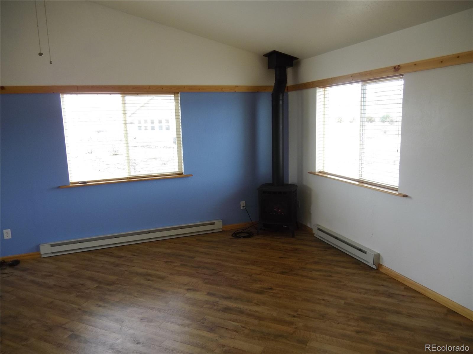 10299 Kingsview Road Austin, CO 81410 - Photo 9 of 40 an empty room with wooden floor and windows