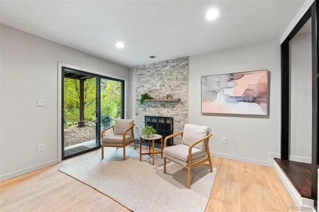 a living room with furniture a fireplace and a large window