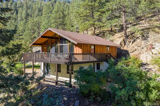 a view of a big house with large trees and plants