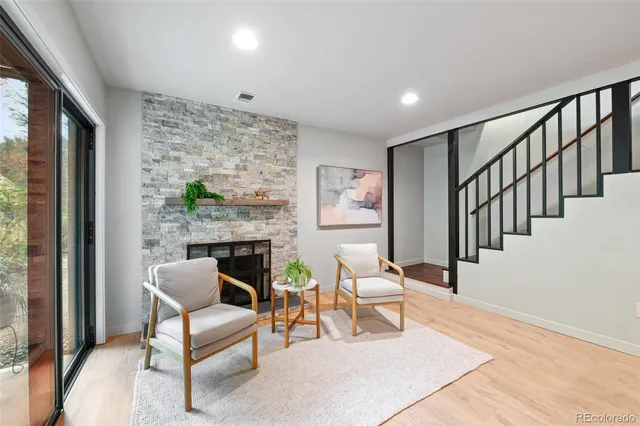 a kitchen with stainless steel appliances kitchen island granite countertop a stove a refrigerator a kitchen island a dining table and chairs with wooden floor