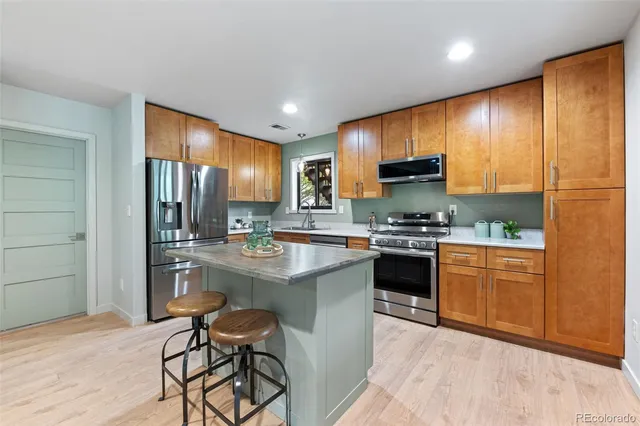 a kitchen with stainless steel appliances granite countertop a sink stove and refrigerator