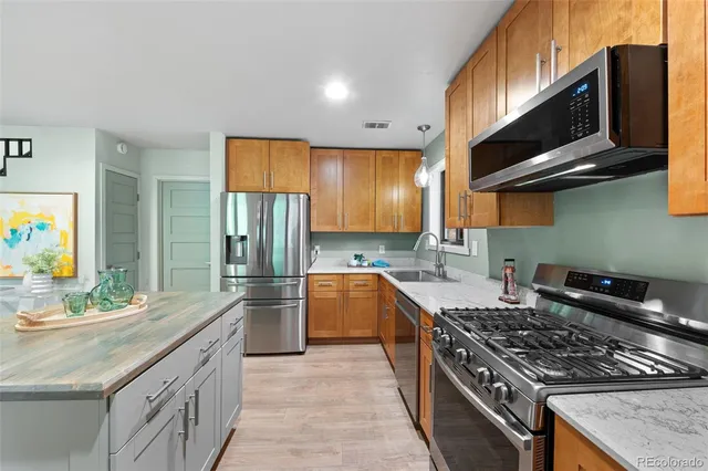 a kitchen with stainless steel appliances granite countertop a sink stove and cabinets