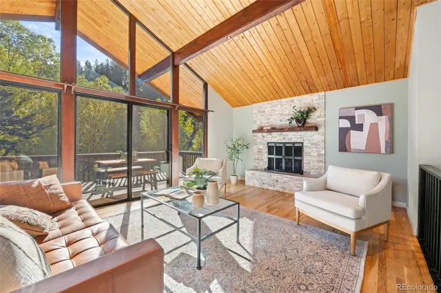 a living room with furniture a fireplace and a floor to ceiling window