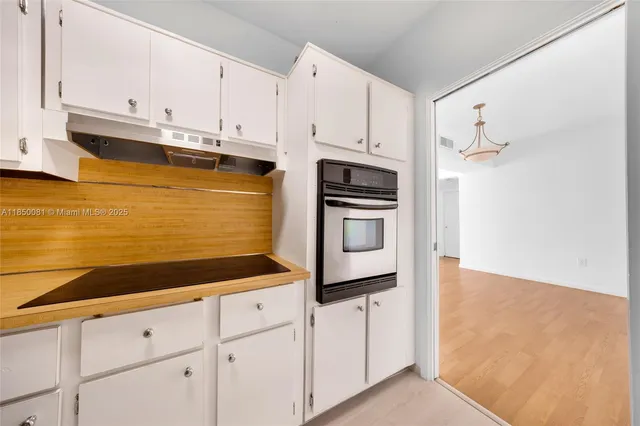 a kitchen with granite countertop white cabinets and stainless steel appliances