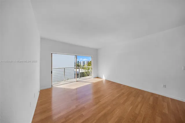 a view of empty room with wooden floor and fireplace
