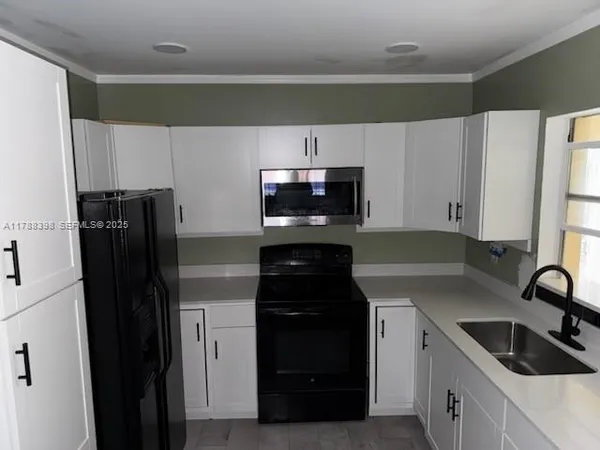 a kitchen with granite countertop a refrigerator and a sink
