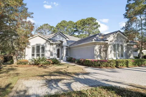 a front view of a house with a yard and potted plants