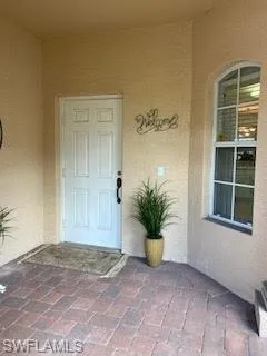 a view of an empty room with a window and potted plants