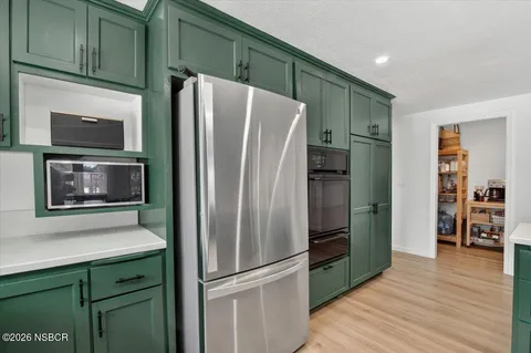 a kitchen with stainless steel appliances granite countertop a refrigerator and a sink