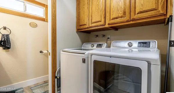 a view of a kitchen with kitchen island a large window cabinets a sink and stainless steel appliances