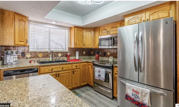 a large white kitchen with a large window and stainless steel appliances