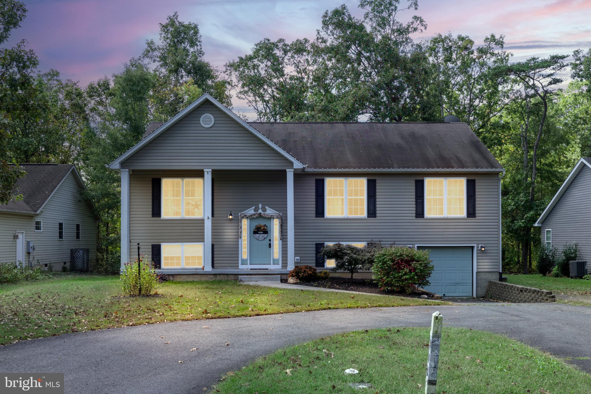 a front view of a house with a yard and trees
