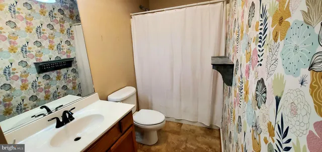 a white toilet sitting next to a bathroom sink